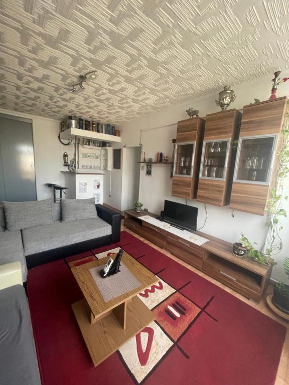 a living room with a couch and a table at Kolor House Apartman in Kazincbarcika