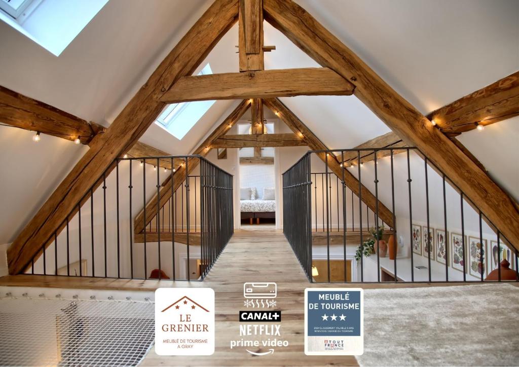 a room with a large wooden ceiling with beams at Gîte le Grenier GRAY in Gray