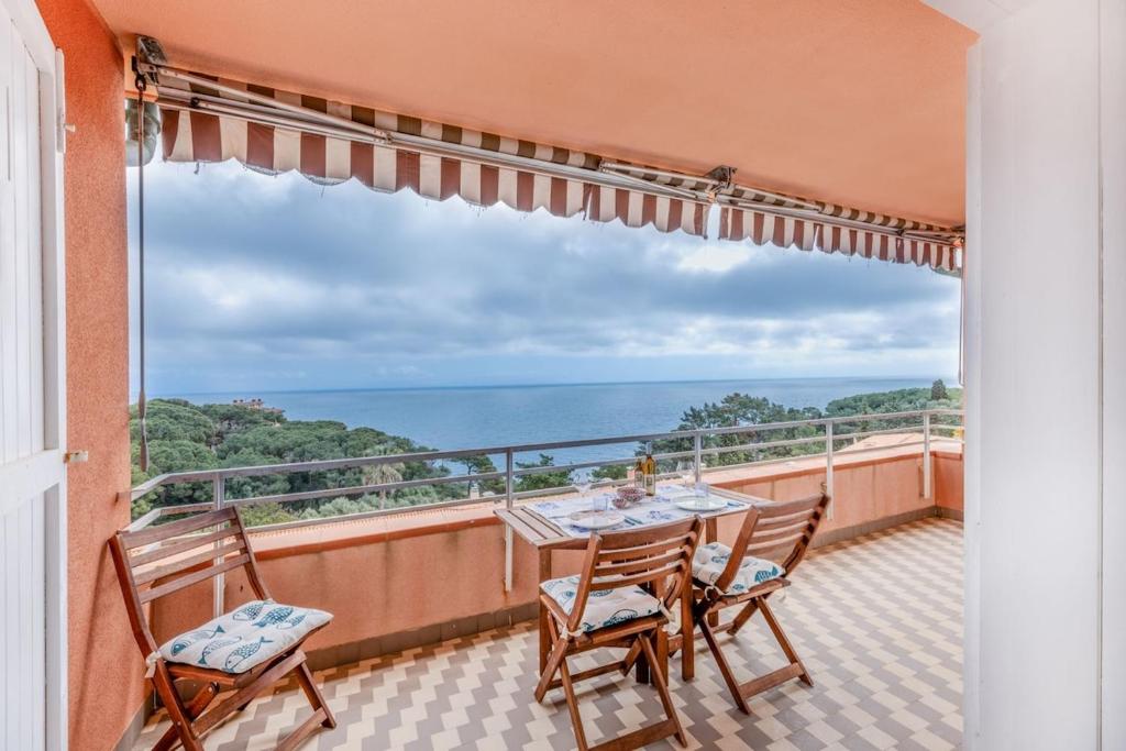 a balcony with a table and chairs and a view of the ocean at Capo d'Arco - Quadrilocale Le Mimose in Capo D'Arco