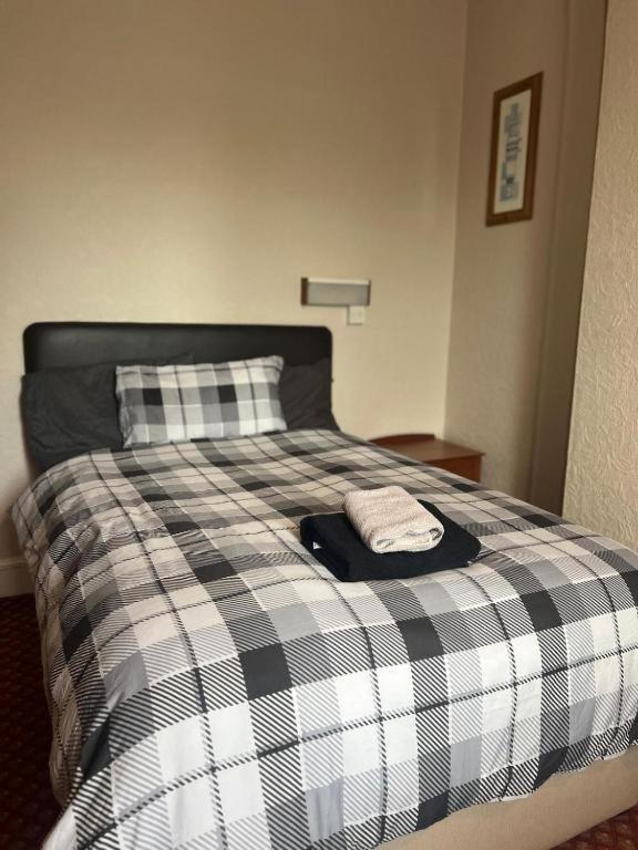a bed with a black and white checkered blanket at Hylands Hotel Double Room with Shared Bathroom & Free Parking in Nottingham