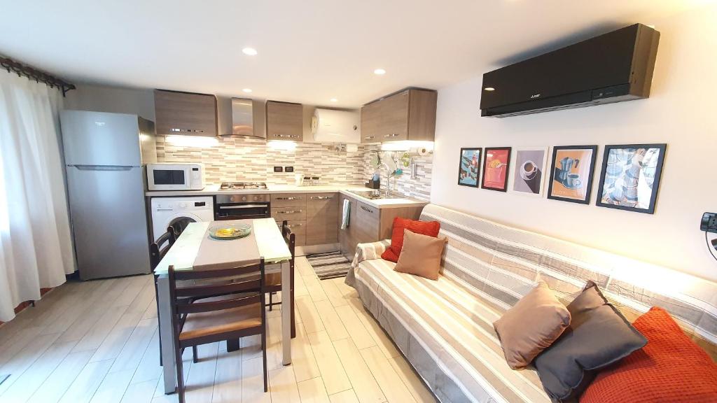 a living room with a couch and a kitchen at Verrazzano Family in Lido di Classe