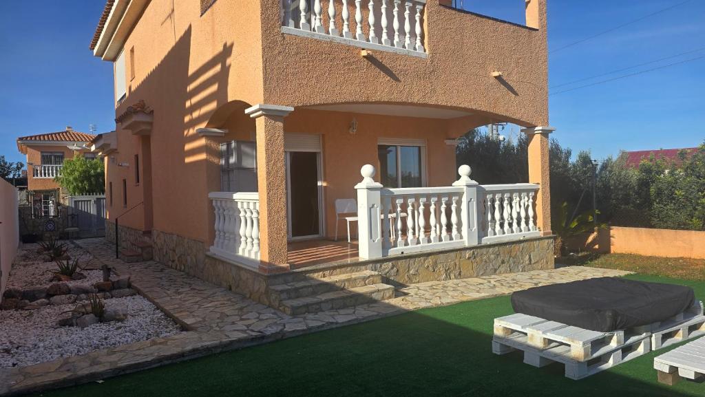 a house with a porch and a lawn at Chalet Kabesa Peñiscola in Peniscola