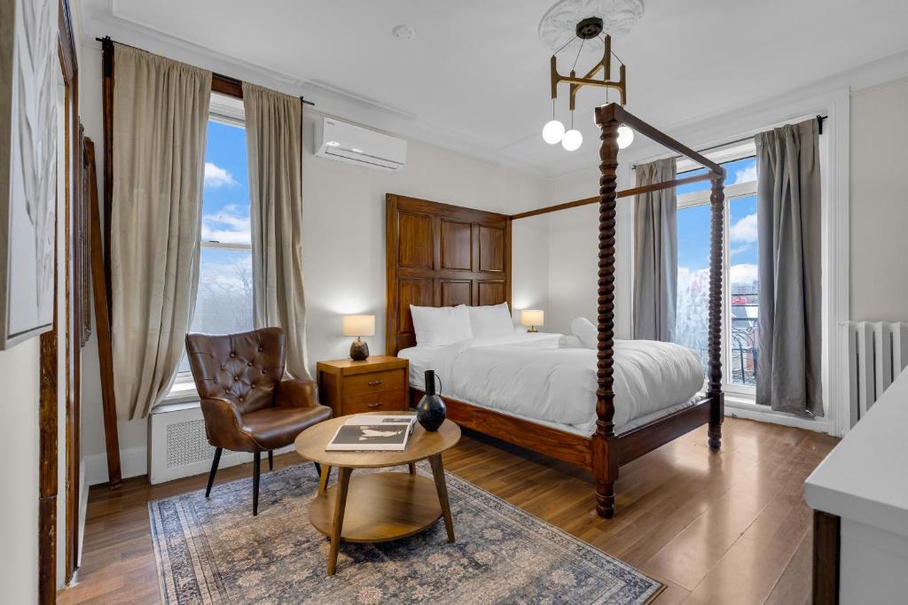 a bedroom with a bed and a chair and a table at Maison Paris- Quartier des Spectacles in Montreal
