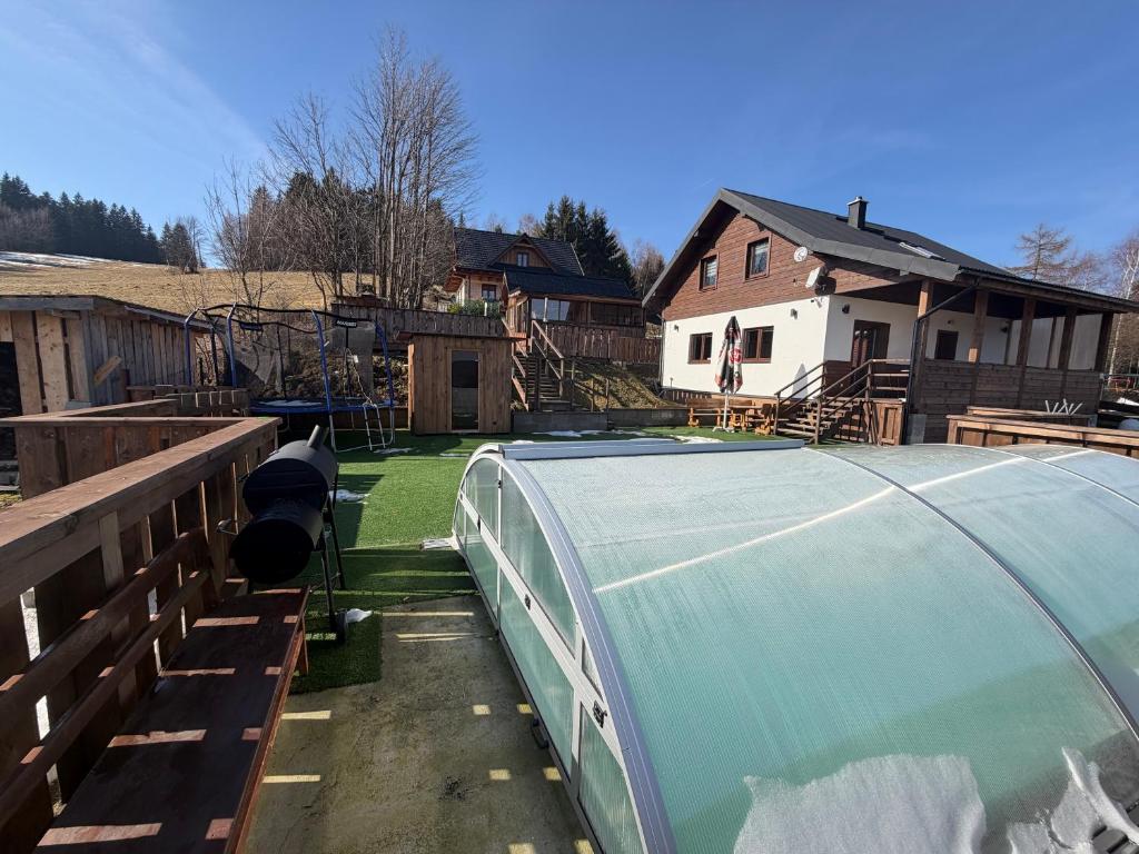 a house with a green tarp on a yard at Wellness chata Rybárie in Klokočov