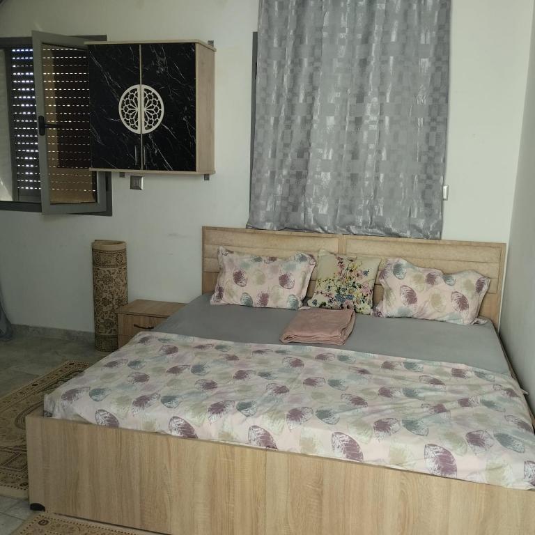 a bedroom with a bed with a wooden frame and pillows at Residence djerba 1 in Houmt Souk
