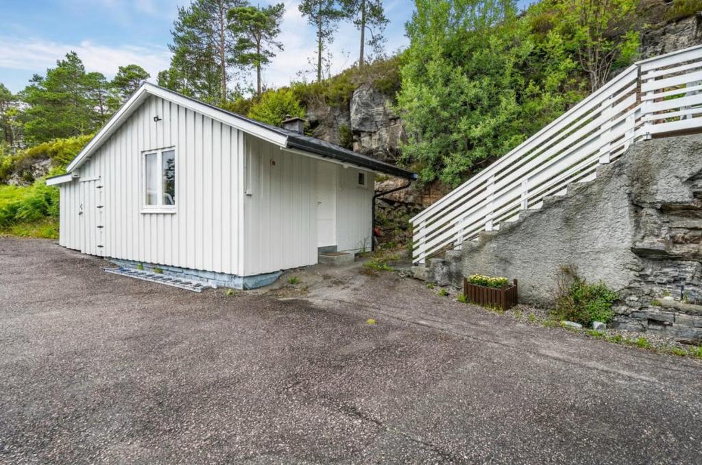 a small white building next to a stone wall at Kristiansund Airport Motell in Kristiansund