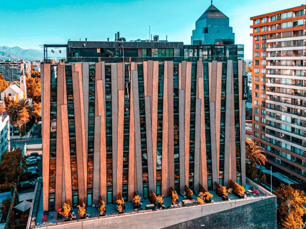 ein hohes Gebäude mit Blumen davor in der Unterkunft Hotel Nodo - El primer hotel de negocios en Chile in Santiago