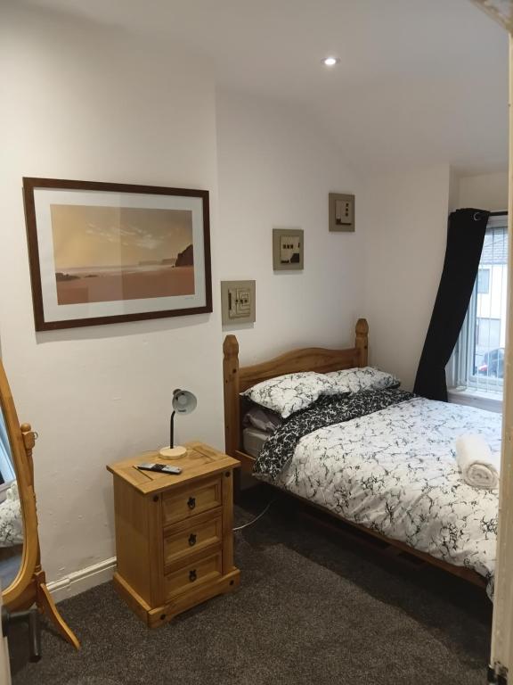 a bedroom with two beds and a table with a lamp at Dale combe in Middleton