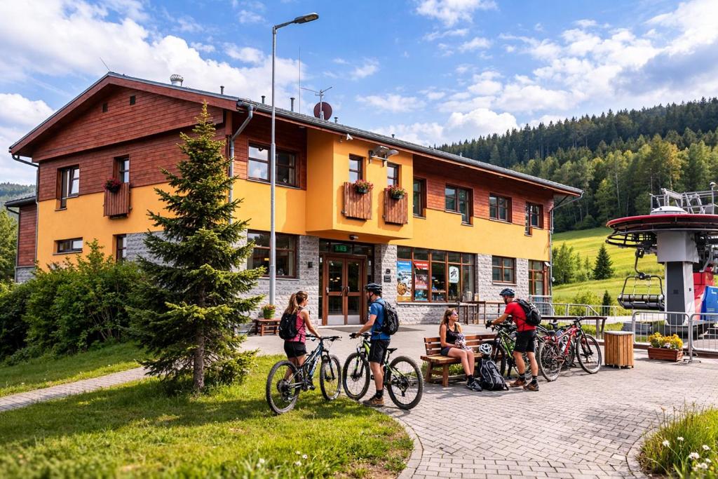 a group of people riding bikes in front of a building at Pension Javorník in Jeřmanice