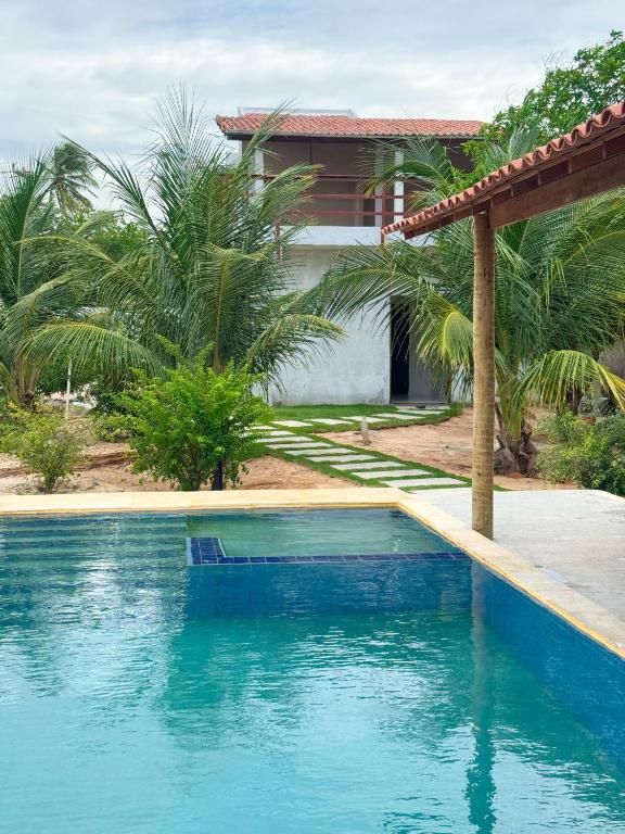 a swimming pool in front of a house at Apart hotel Refúgio tropical Icarai de amontada in Amontada