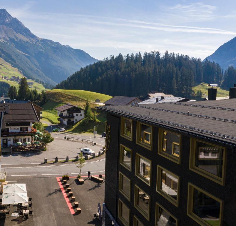 a building with a view of a street and mountains at Berghotel Kleiner Biber in Warth am Arlberg