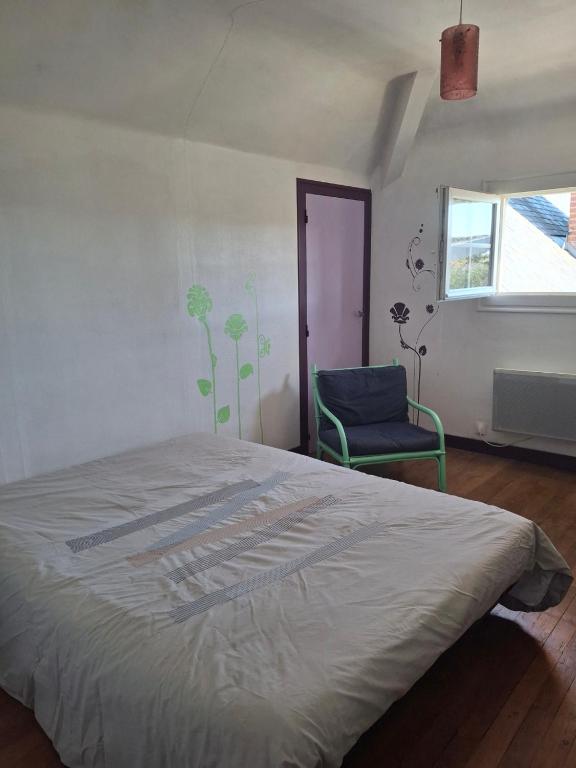 a bedroom with a bed and a blue chair at Chambre dans village tranquille in Saint-Laurent-de-la-Plaine