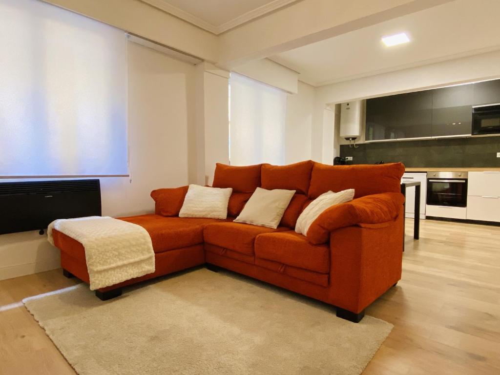 an orange couch sitting in a living room at Apartamento en Eibar in Éibar