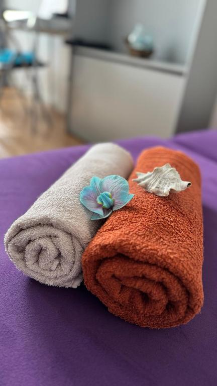 a towel with a flower on it on a bed at Sleep&Coffee&Go in Trier