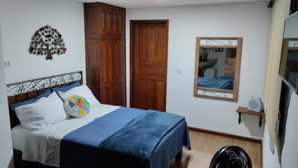 a bedroom with a bed with a blue blanket and a mirror at Central Apartment 03 in Ouro Preto