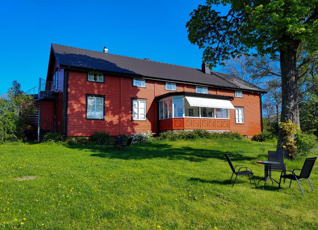 a red house with a table and chairs in front of it at Granbergs Gästhem in Eckerö
