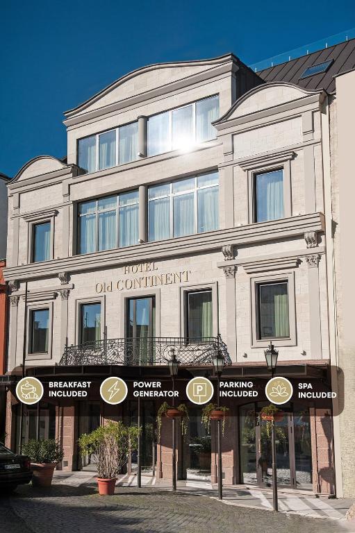 a large white building with a sign in front of it at Old Continent Hotel in Uzhhorod