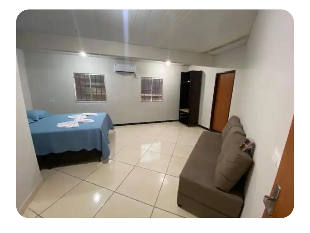 a bedroom with a bed and a couch in a room at Aluguel por temporada Triunfo-PE in Triunfo