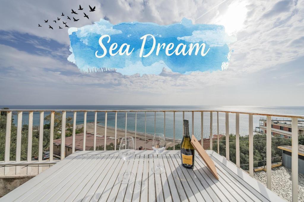 a bottle of wine sitting on a table on a beach at Sea Dream - Vista Mare - Giardino - Box Privato in Bergeggi