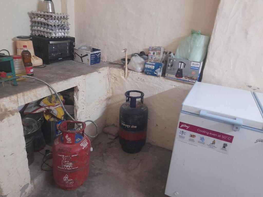 a kitchen with a stove and a refrigerator in a room at Hotel kanha Royal Inn in Jodhpur