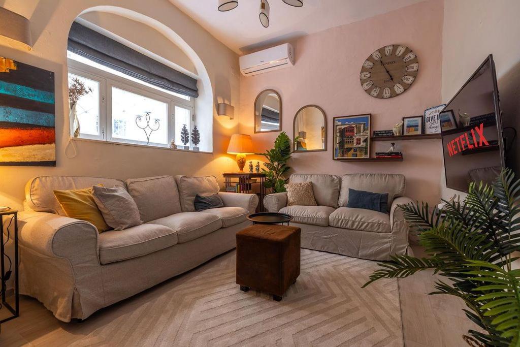 a living room with a couch and a clock on the wall at Elegant Maltese Townhouse in Attard