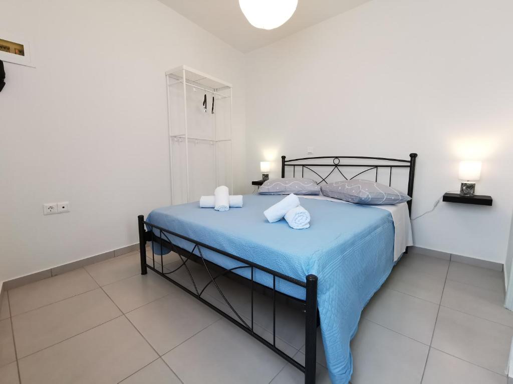 a bedroom with a bed with a blue comforter at Meltemi Chora Amorgos Panoramic View in Amorgos