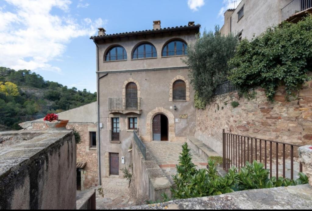 an old stone building with a staircase leading up to it at Cal Vidal in Mura
