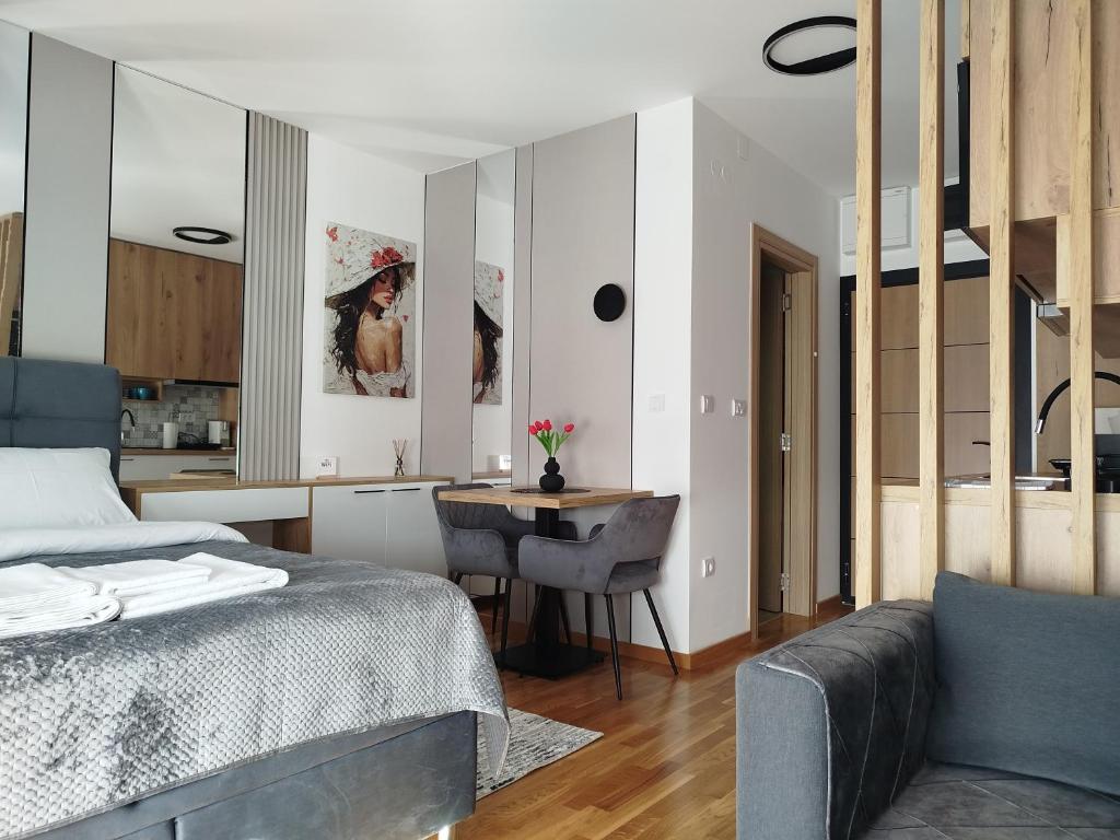 a bedroom with a bed and a table and a kitchen at Studio Sky in Smederevo