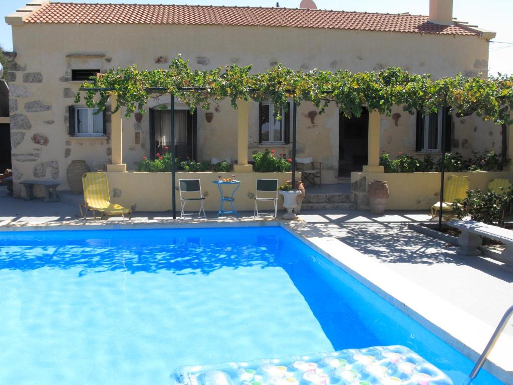 a villa with a swimming pool in front of a house at Stathis Villa in Vamos