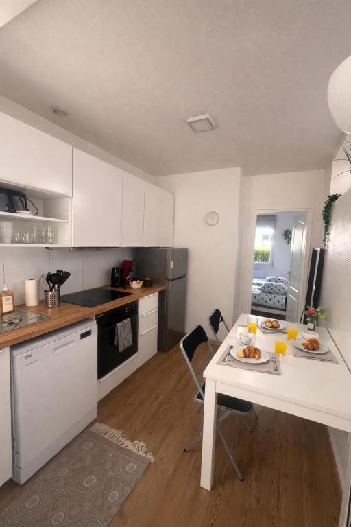a kitchen with a white table with food on it at Studio cosy avec parking, tram direct Strasbourg 7 min in Illkirch-Graffenstaden