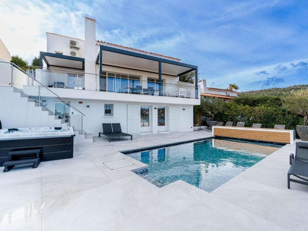 a house with a swimming pool in front of it at Sara in Les Issambres