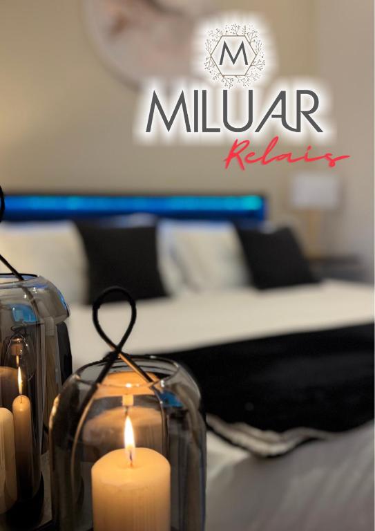 two candles in front of a living room with a couch at MILUAR Relais - Piazza Fuga in Naples