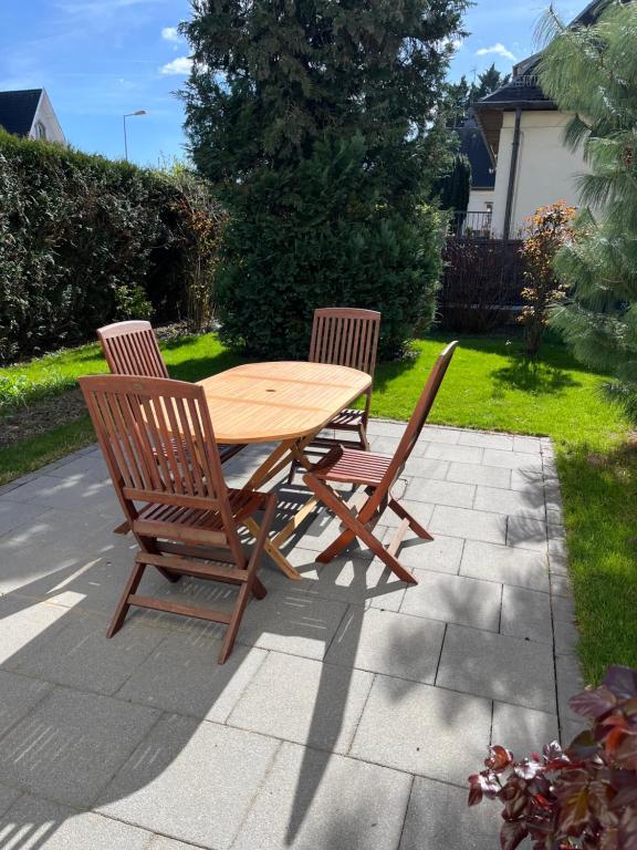 a wooden table and two chairs sitting on a patio at Chez F & G terrasse privée dans jardin - parking in Sélestat