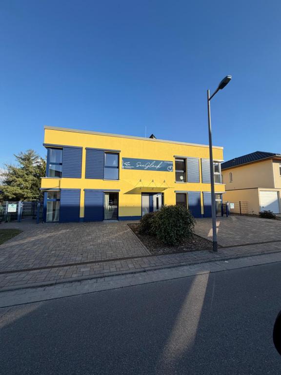 a yellow and blue building on the side of a street at Ferienwohnungen Seeglück in Senftenberg