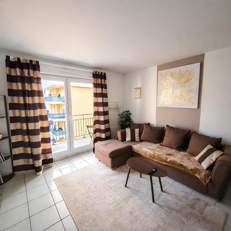 a living room with a couch and a table at T3 spacieux hyper-centre - Familles & Pros - Genève à 5 min in Saint-Julien-en-Genevois