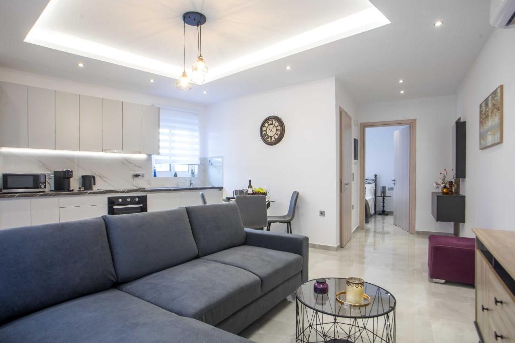 a living room with a couch and a kitchen at Hara's Cozy Apartment with Private Parking in Rhodes Town