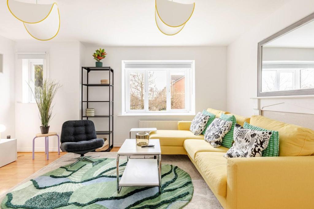 a living room with a yellow couch and a rug at Spacious 4-Bed Home with Workspace in Coundon
