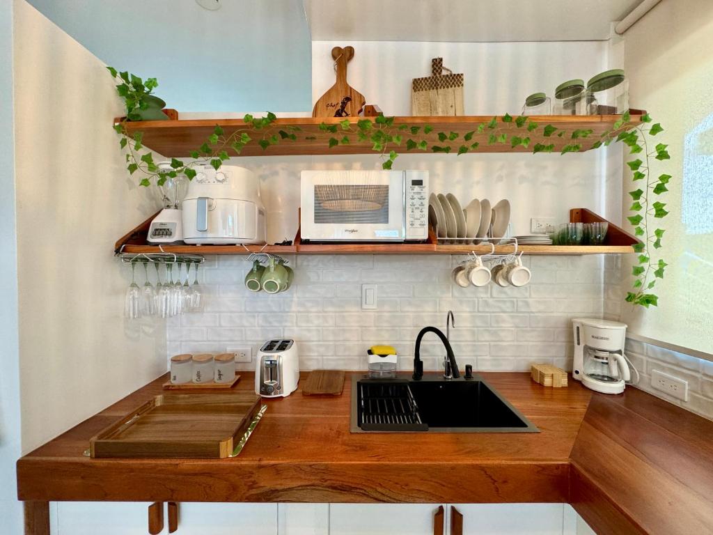 a kitchen with a sink and a microwave on a counter at BoHo Galapagos in Puerto Ayora