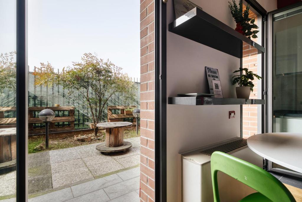 a kitchen with a view of a patio with a table at Linate Airport - Apt with Garden in Milan