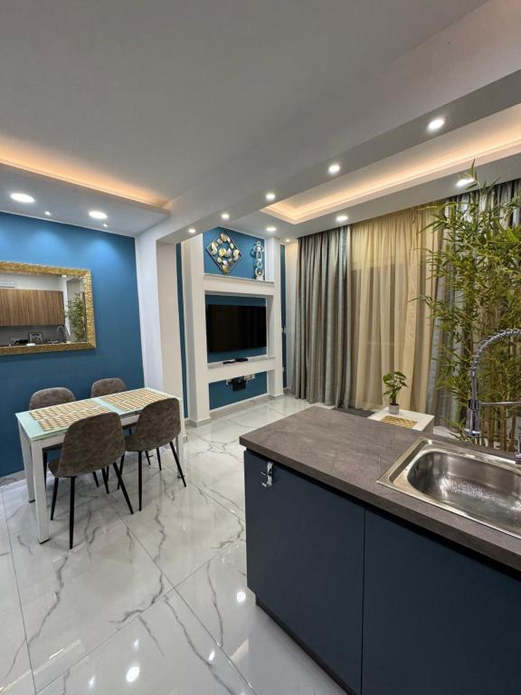 a kitchen with a sink and a table with chairs at B&S Accommodation Newly Renovated Penthouse 253 in Żejtun