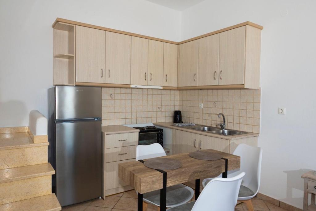 a kitchen with a table and a stainless steel refrigerator at Sunset 7.59 in Mikonos