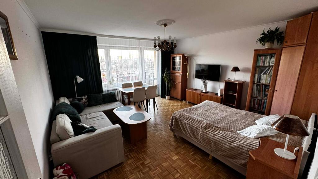 a living room with a couch and a bed and a table at Cracow View Rooms in Krakow