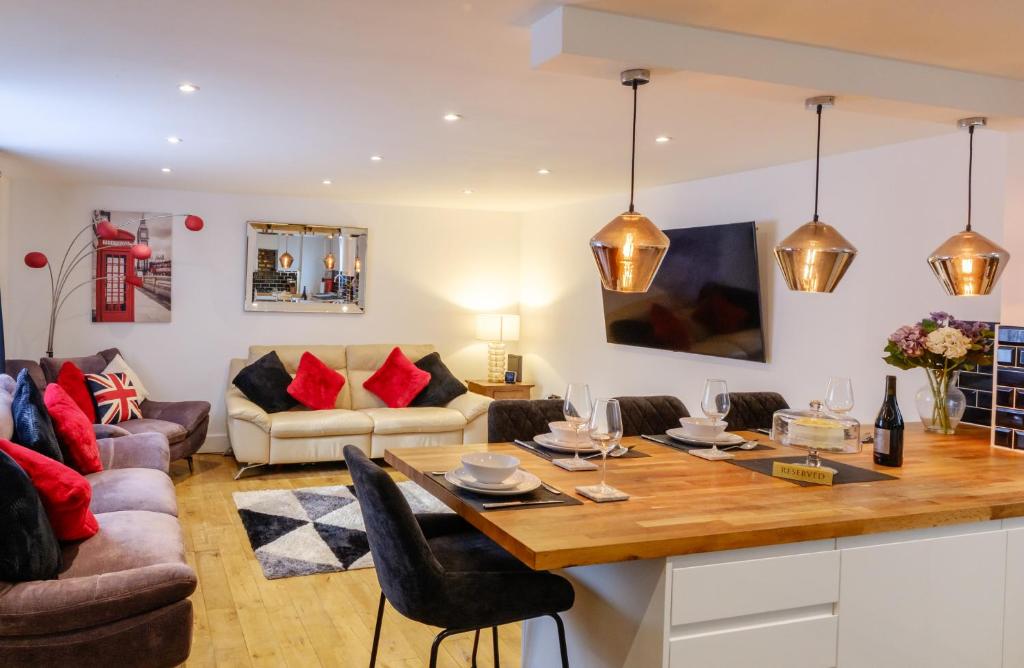 a kitchen and living room with a wooden table at Modern Central St Albans Maisonette Free Parking Sleeps 4 Fast Wifi in St. Albans