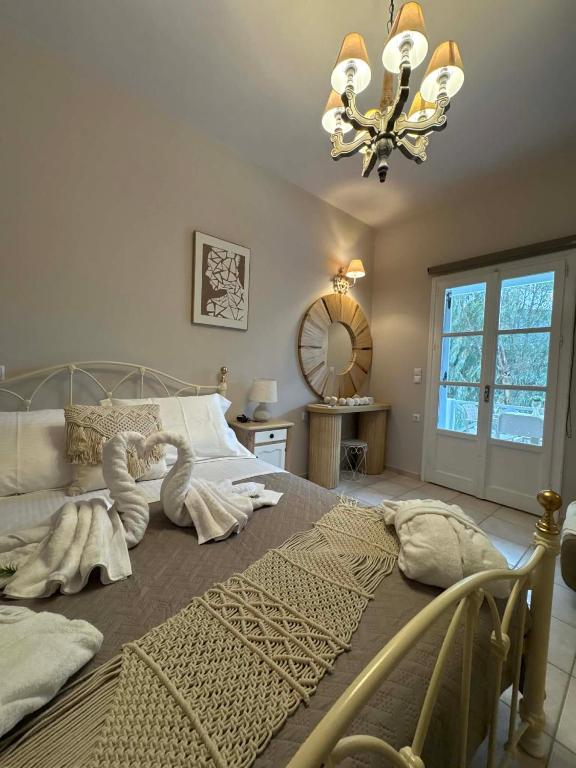 a bedroom with a large bed with a chandelier at Το Αίθριο in Galissas