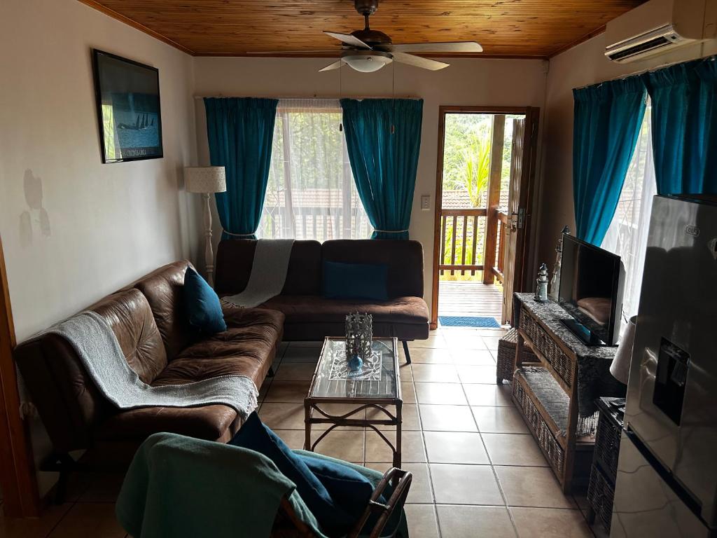 a living room with a couch and a tv at Die Anker Kothuis in Southbroom