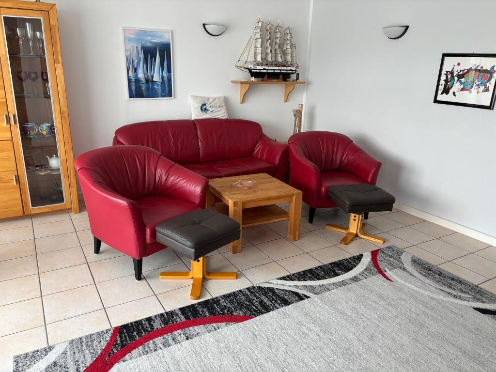 a living room with two red chairs and a table at Ferienwohnung Andresen in Rerik