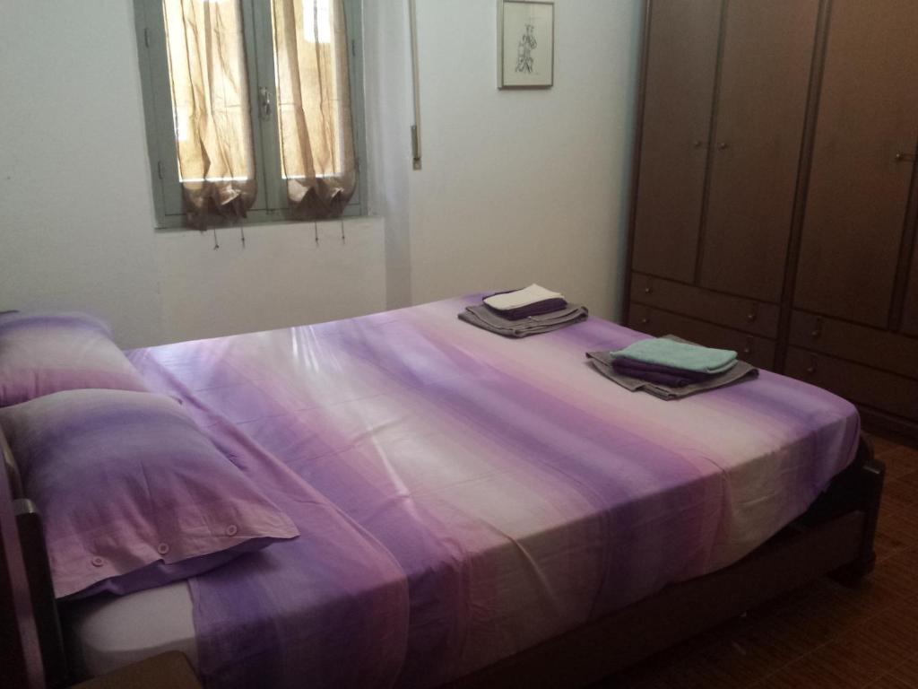 een paars bed met twee handdoeken erop bij Casa Michele in Pau