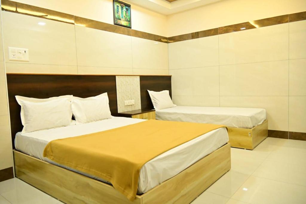 a bedroom with two beds in a room at VRJInn in Vellore