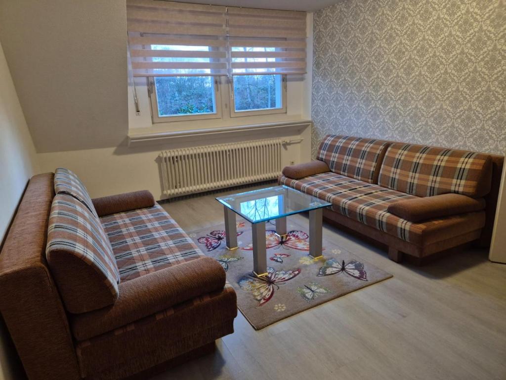 a living room with two couches and a coffee table at Zimmervermietung Lena in Lengerich