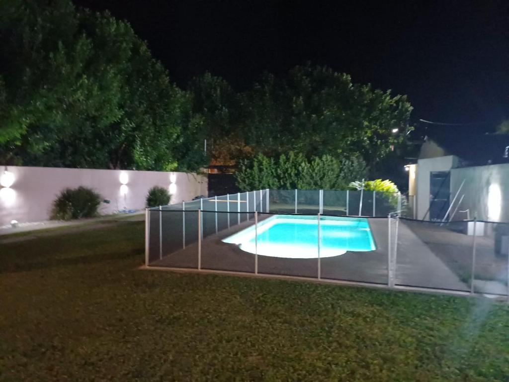 a fence around a swimming pool at night at Casa Quinta Malu in Gualeguaychú